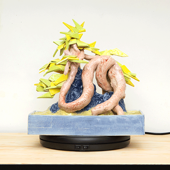 Snake-like ceramic bonsai glazed in pink, blue, yellow, and green with trapezoidal leaves alternating with rear view of sculpture revealing unglazed architectural scaffolding-like support structure